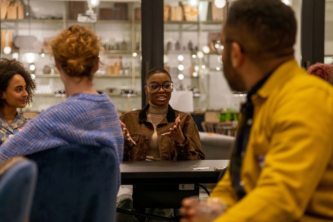 Two people in the background and in the foreground chat