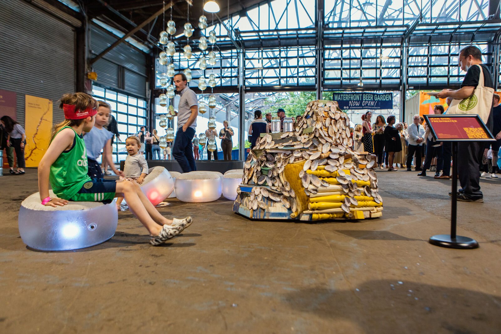 Children sit and play on illuminated floor pillows
